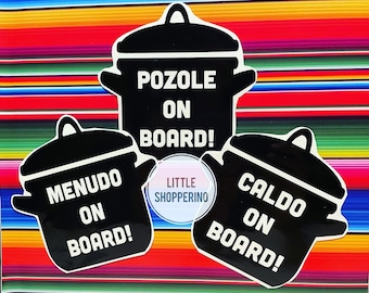 May include: Three black and white pot-shaped stickers with the text "Pozole on Board!" "Menudo on Board!" and "Caldo on Board!" on a colorful striped background.