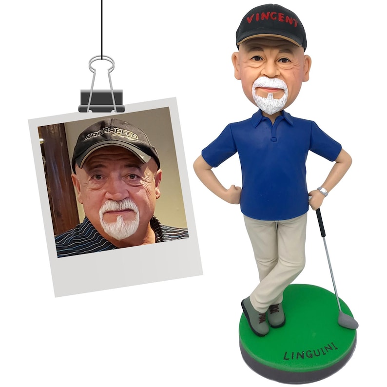 Puede incluir: Figura de bobblehead personalizada con tem&aacute;tica de golf de un hombre con polo azul, pantalones color caqui y gorra negra con "Vincent" en rojo. La figura est&aacute; sobre una base verde con "Linguini" impreso. Se adjunta una foto.