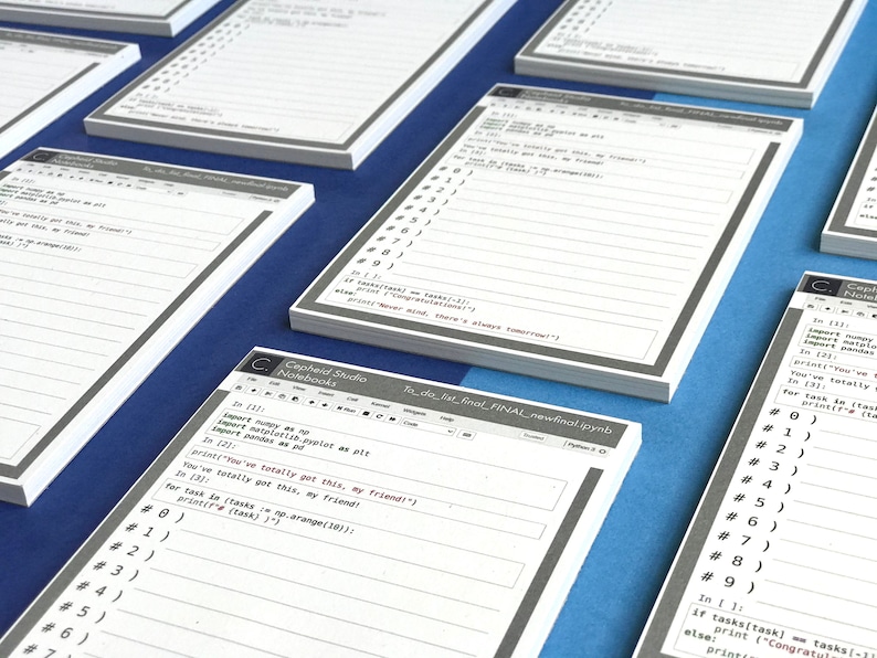 May include: A stack of white paper notebooks with a gray border and the text "Cepheid Studio Notebooks" printed on the front. The notebooks are designed for coding and feature a Python code example with the text "To do list final FINAL newfinal.ipynb".