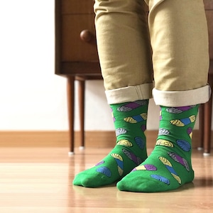 May include: A pair of green socks with a colorful pattern of abstract shapes. The socks are made of a soft, comfortable material and are perfect for everyday wear.
