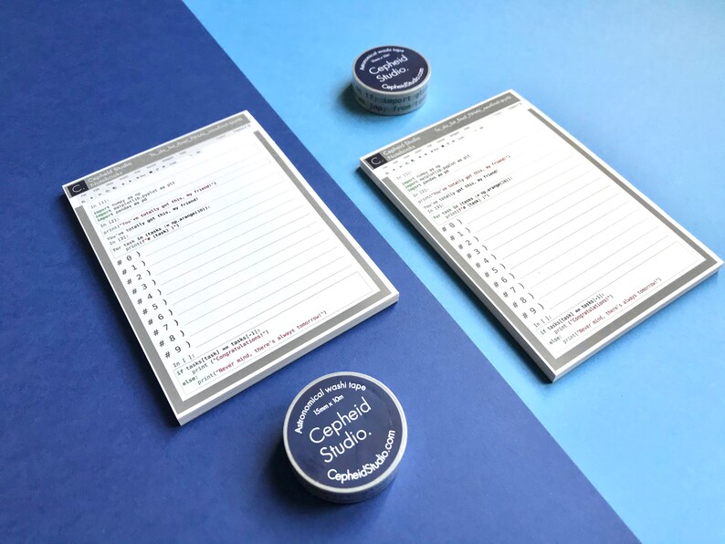 Pu&ograve; includere: Due set di blocchi note bianchi con linee grigie e codice stampato su di essi. I blocchi note sono su una superficie blu. Due rotoli di washi tape sono sulla superficie, uno &egrave; blu e l'altro &egrave; bianco. Il washi tape ha il testo "Astronomical washi tape" e "Cepheid Studio."