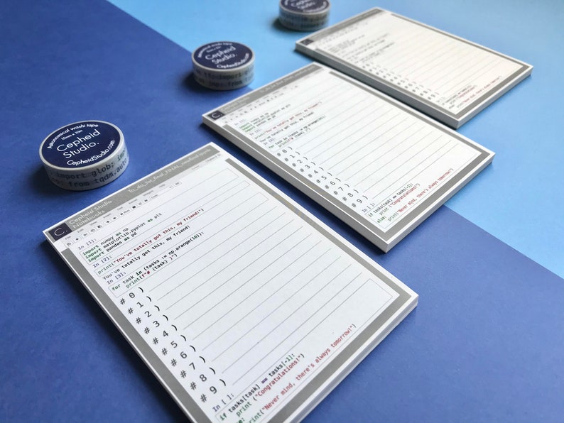 Pu&ograve; includere: Due set di blocchi note bianchi con bordi grigi e pagine a righe. Le pagine dei blocchi note hanno un tema di codice informatico con un design di schermo del computer grigio e bianco. I blocchi note sono su uno sfondo blu e blu chiaro. I blocchi note hanno il testo "Cepheid Studio" stampato su di essi.