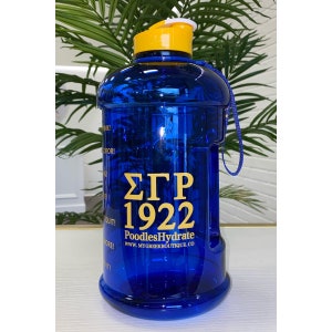 May include: Blue water bottle with a yellow lid and a gold Greek letter design that says "ΣΓΡ 1922" and "PoodlesHydrate" with the website "www.mygreekboutique.co".