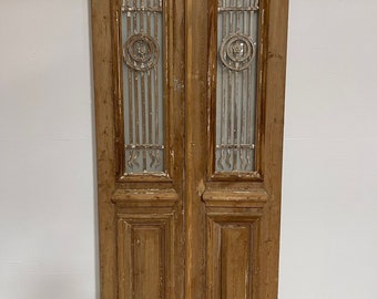 May include: A pair of antique wooden double doors with intricate ironwork details and frosted glass panels. The doors are a light brown color and have a distressed finish.