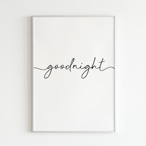 May include: A white framed print with the word "goodnight" written in black cursive script.