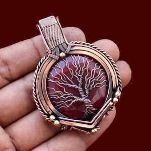 May include: A white ceramic mug with a black handle and the text "But First, Coffee" in a bold, black font. The mug is set against a blurred background. The mug appears to be approximately 10 cm tall.