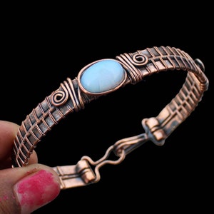 Pulsera tipo brazalete hecha a mano con alambre de cobre y ópalo de fuego envuelto