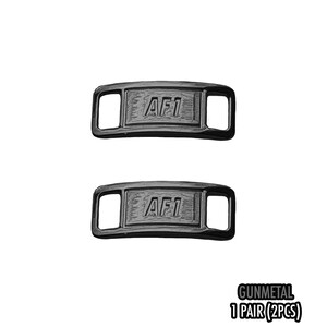 May include: Two gunmetal-colored shoe lace tags with the text "AF1" embossed on each. The tags have a rectangular shape with rounded corners and two rectangular openings. The text "GUNMETAL 1 PAIR (2PCS)" is also visible.
