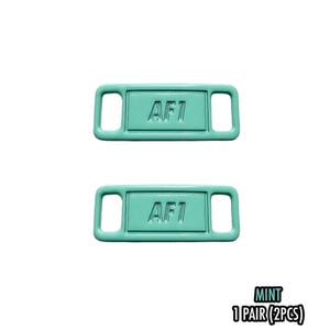 May include: Two mint-colored shoe tags with the text "AF1" embossed on each. The tags are rectangular with rounded corners and two rectangular holes on each side. The bottom right corner of the image has the word "MINT" and "1 PAIR (2PCS)".