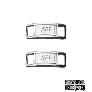 May include: Two shiny silver AF1 shoelace tags. Each tag is rectangular with rounded edges and features the letters "AF1" in the center. The tags have a polished, reflective surface. The text "SHINY SILVER 1 PAIR (2PCS)" is at the bottom.