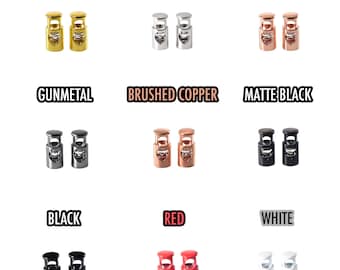 May include: A set of 10 toggle cord locks in various colors, including gold, silver, rose gold, gunmetal, brushed copper, matte black, black, red, and white. Each lock is made of metal and has a heart-shaped design.