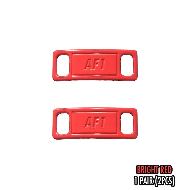 May include: Two bright red rectangular shoe accessories with the text "AF1" embossed on each. Each accessory has two holes. The text "BRIGHT RED 1 PAIR (2PCS)" is in the bottom right corner.