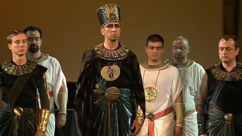 May include: A group of men wearing elaborate costumes, including a pharaoh with a tall headdress and a gold-colored collar. The men are standing in a line, and they are all looking at the camera.