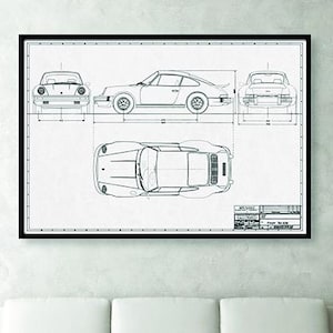 May include: Black framed blueprint art print of a classic sports car. The print shows the car from multiple angles: front, side, top, and rear. The car is depicted in a detailed line drawing on a white background.