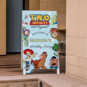 May include: A light blue, A-frame sign with the text "TWO INFINITY and beyond!" and "Welcome to MICHAEL'S Birthday Party". The sign features cartoon characters from the Toy Story movie.