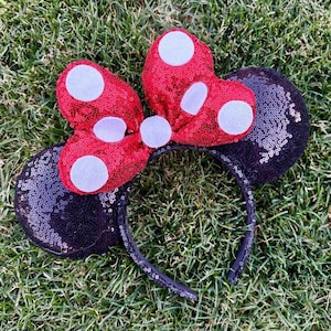 May include: Black and red sequined Minnie Mouse ears headband with a white polka dot bow.