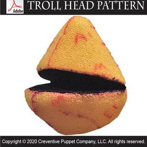 Puede incluir: Un patrón digital en PDF titulado TROLL HEAD PATTERN que muestra un objeto amarillo, texturizado y redondeado con una abertura bucal horizontal negra y ancha, y marcas rojas tenues en la superficie, sobre un fondo blanco.