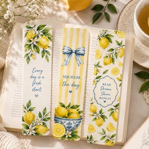 Puede incluir: Tres marcapáginas rectangulares con ilustraciones de limones. El de la izquierda dice Every day is a fresh start. El central tiene rayas amarillas, un lazo azul y SQUEEZE the day. El de la derecha muestra el texto READ Dream Shine REPEAT.