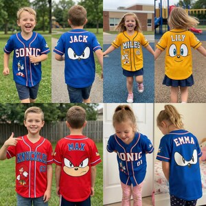 Peut inclure: Plusieurs maillots de baseball pour enfants aux couleurs vives : bleu, rouge et jaune. Ils pr&eacute;sentent des personnages de Sonic le H&eacute;risson et des noms tels que "SONIC", "JACK", "MILES", "LILY", "KNUCKLES", "MAX" et "EMMA", avec des graphismes.