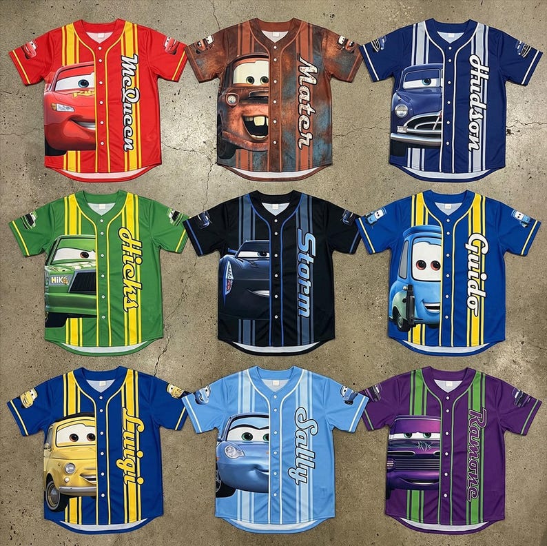 Puede incluir: Nueve camisetas de b&eacute;isbol con personajes de la pel&iacute;cula animada Cars. Cada camiseta tiene un esquema de color y dise&ntilde;o de personaje diferente, incluyendo McQueen, Mater, Hudson, y otros. Las camisetas tienen mangas cortas y botones frontales.