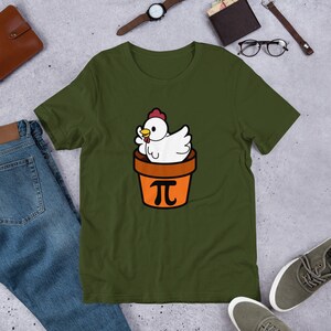 May include: A green t-shirt with a white chicken in a brown pot with a pi symbol on the front.