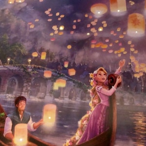 May include: A painting depicts a romantic scene with a woman in a pink dress and a man in a boat, releasing glowing lanterns into the night sky. A bridge and buildings are visible in the background, with many floating lanterns.
