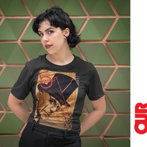 May include: A woman wearing a black t-shirt with a vintage poster design featuring a man in a hat and the text "5 минут".