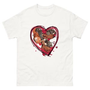 Könnte beinhalten: Weißes T-Shirt mit einem roten Herzdesign mit handgezeichnetem Umriss. Im Inneren des Herzens befinden sich Bilder von Kätzchen und Teddybären. Kleine rote Herzen sind um das Hauptdesign verstreut. Das T-Shirt besteht aus schwerem Baumwollmaterial.