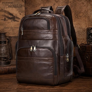 May include: A brown leather backpack with multiple zippered compartments and adjustable shoulder straps. The backpack has a top handle and a padded back panel. The bag is made of a rich, dark brown leather and features silver-toned hardware.