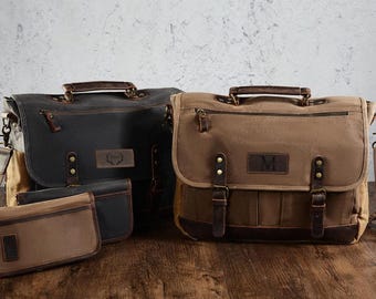 Könnte beinhalten: Zwei Canvas-Kuriertaschen und eine kleine Tasche in Schwarz und Braun. Die Taschen haben Lederakzente, obere Griffe und verstellbare Schultergurte. Die Taschen haben eine rechteckige Form mit Klappenverschluss und mehreren Taschen.