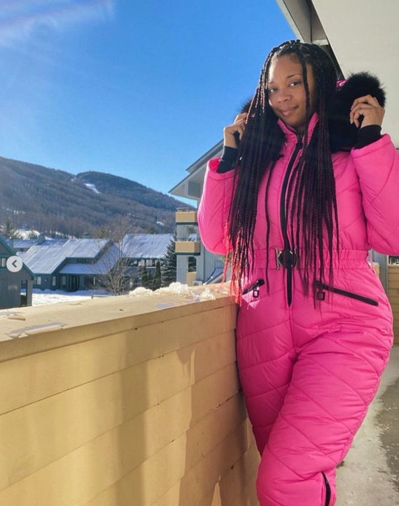 Mujer en un parque de invierno. dama en traje deportivo rosa. mujer con  moto de nieve.