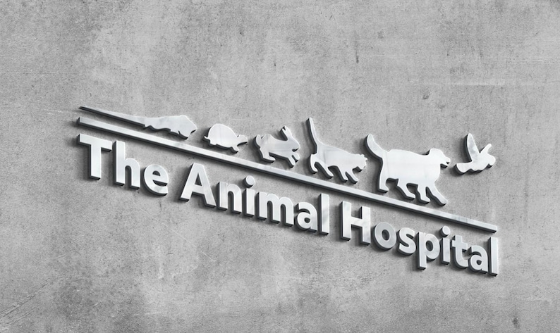 May include: A silver-toned metal sign featuring the text The Animal Hospital in a bold, sans-serif font. Above the text, a horizontal line supports a series of small, metallic animal silhouettes, including a lizard, turtle, rabbit, cat, dog, and bird.