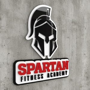 May include: A three-dimensional wall sign featuring a black Spartan helmet icon above a rectangular plaque with the red text SPARTAN and the black text FITNESS ACADEMY, all mounted on a textured gray concrete surface with a white border.