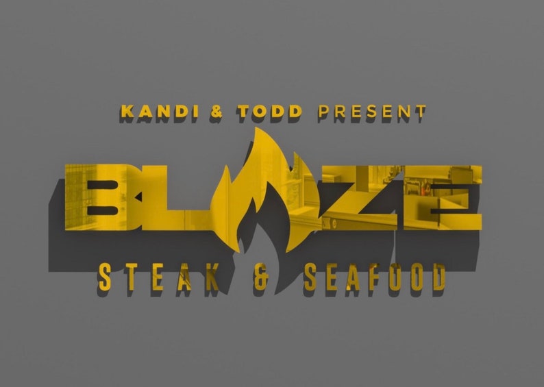 Puede incluir: Un logotipo dorado con el texto "KANDI & TODD PRESENT" sobre la palabra "BLAZE" en un dise&ntilde;o de llama estilizado. Debajo de la palabra "BLAZE" est&aacute; el texto "STEAK & SEAFOOD".