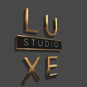 Puede incluir: Letras de metal de color dorado que deletrean "LUXE STUDIO" sobre un fondo negro. Las letras est&aacute;n en relieve y tienen un efecto 3D.