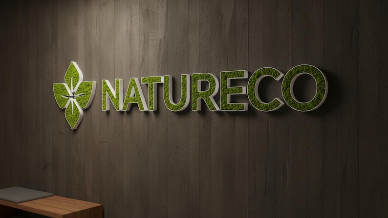 May include: A three-dimensional wall sign featuring the word NATURECO in white capital letters filled with green preserved moss, accompanied by a leaf-shaped logo icon also filled with green moss, mounted on a dark brown vertical wood panel.