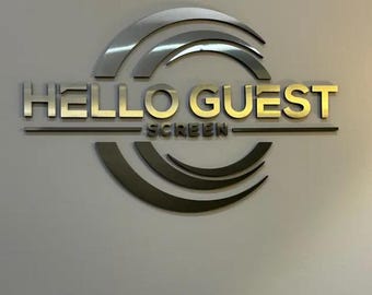 Könnte beinhalten: Ein Wandschild mit dem Schriftzug HELLO GUEST in großen, goldfarbenen Metallbuchstaben, darunter das Wort SCREEN in kleineren Buchstaben. Das Design umfasst zwei Sätze aus je drei geschwungenen, dunkelmetallischen Bögen, die den Text einrahmen.