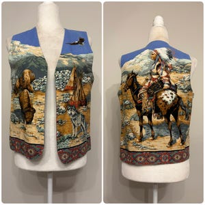 May include: A sleeveless vest featuring a printed landscape scene with a buffalo, a wolf, a flying eagle, and teepees on the front panels. The back panel displays a person in traditional regalia riding a spotted horse. A geometric border trims the hem.