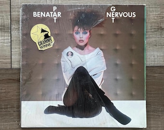 Può includere: Copertina dell'album in vinile con Pat Benatar. L'album si intitola "Nervous" e include un adesivo "Grammy Winner". La copertina mostra una donna con un top bianco e pantaloni neri.