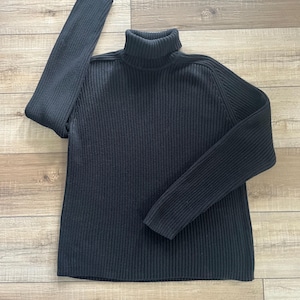 May include: A set of three ceramic mugs with a speckled, matte finish. The mugs are in shades of cream, light gray, and dark gray. Each mug has a simple, modern design and a rounded handle.