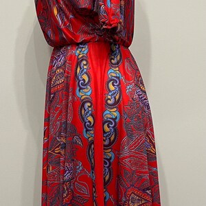 May include: A red dress with a floral print. The dress has a gathered neckline and short sleeves. The dress is on a white mannequin.