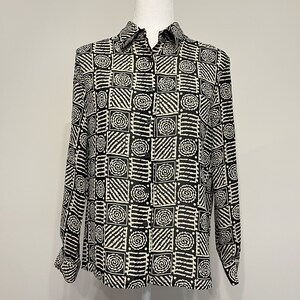 May include: A black and white long-sleeved button-up shirt with a geometric pattern of squares and swirls.