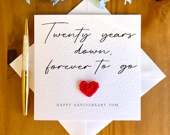 May include: A white card with the text "Twenty years down, forever to go" and a red crocheted heart. The card also says "Happy Anniversary Tom".