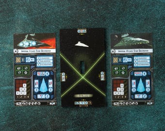 May include: Three Star Wars game cards featuring star destroyers. The cards have detailed graphics, including ship schematics, numerical values, and the text "IMPERIAL F-CLASS STAR DESTROYER" and "IMPERIAL II-CLASS STAR DESTROYER". The central card has a starship silhouette and the text "IMPERIAL FORCE STAR DESTROYERS".