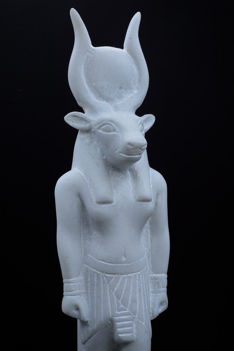 May include: White marble statue of an Egyptian god with bull horns and a human body.