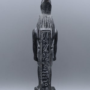 K&ouml;nnte beinhalten: Schwarze Steinstatue eines &auml;gyptischen Gottes mit Hieroglyphen, die auf die Vorderseite geschnitzt sind. Die Statue steht auf einem rechteckigen Sockel.