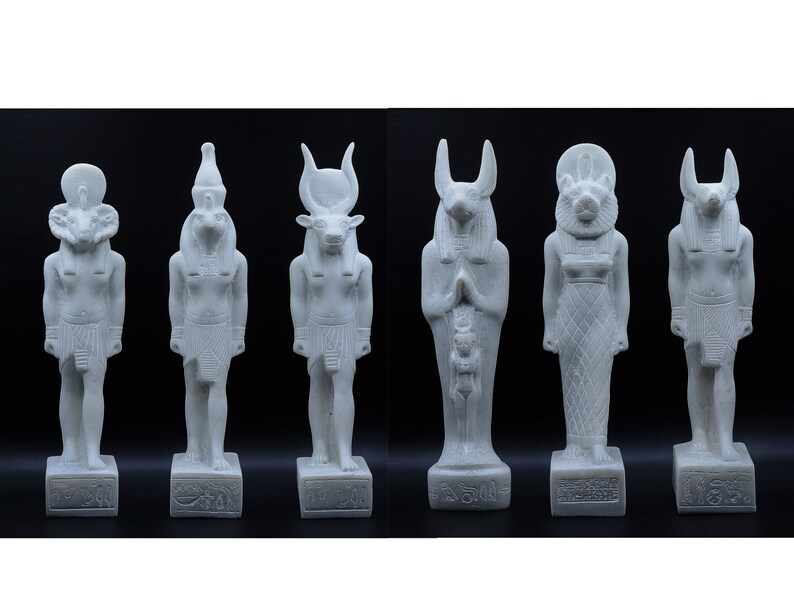 May include: Set of six white Egyptian god statues with different animal heads, including a ram, a jackal, a bull, a falcon, a lion, and a baboon. The statues are standing on rectangular bases with hieroglyphics.