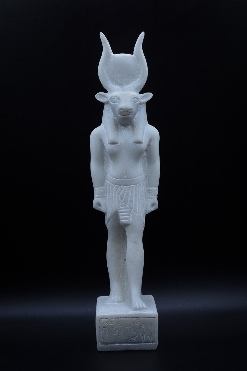 May include: White statue of an Egyptian god with a bull's head, standing on a base with hieroglyphs.