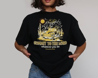 Puede incluir: Camiseta negra con un gráfico amarillo de un camión vintage, sol y paisaje desértico. El texto "COMMIT TO THE LORD whatever you do Proverbs 16:3" está impreso en amarillo. La camiseta es de estilo casual.