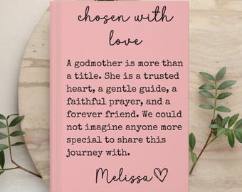 May include: A pink book with black text that reads: chosen with love. A godmother is more than a title. She is a trusted heart, a gentle guide, a faithful prayer, and a forever friend. We could not imagine anyone more special to share this journey with. Melissa.